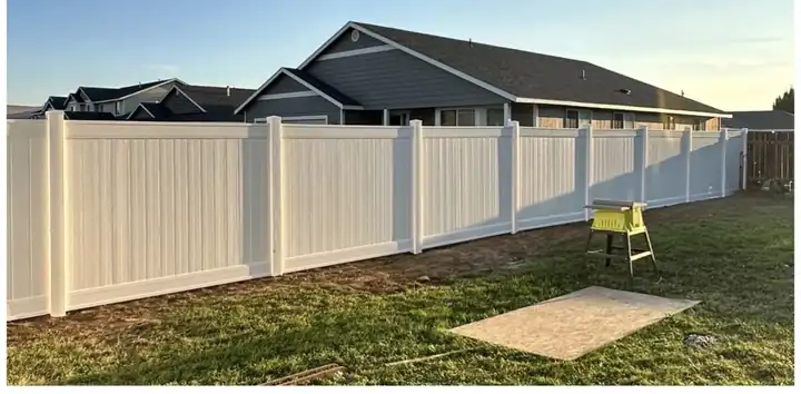 New white vinyl privacy fence installed by Abel's & Sons along the same lawn