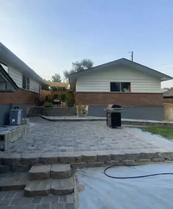 Finished grey paver patio with block steps built by Abel's & Sons