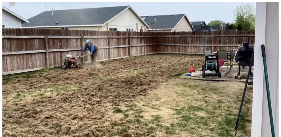Abel's & Sons crew member tilling a bare, patchy backyard before sod